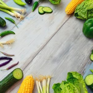 An assortment of fresh vegetables on a wooden table, perfect for healthy cooking.