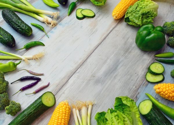 An assortment of fresh vegetables on a wooden table, perfect for healthy cooking.