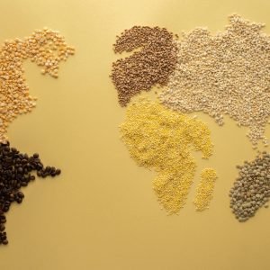 A world map creatively illustrated using diverse grains on a yellow background. Perfect for agricultural themes.